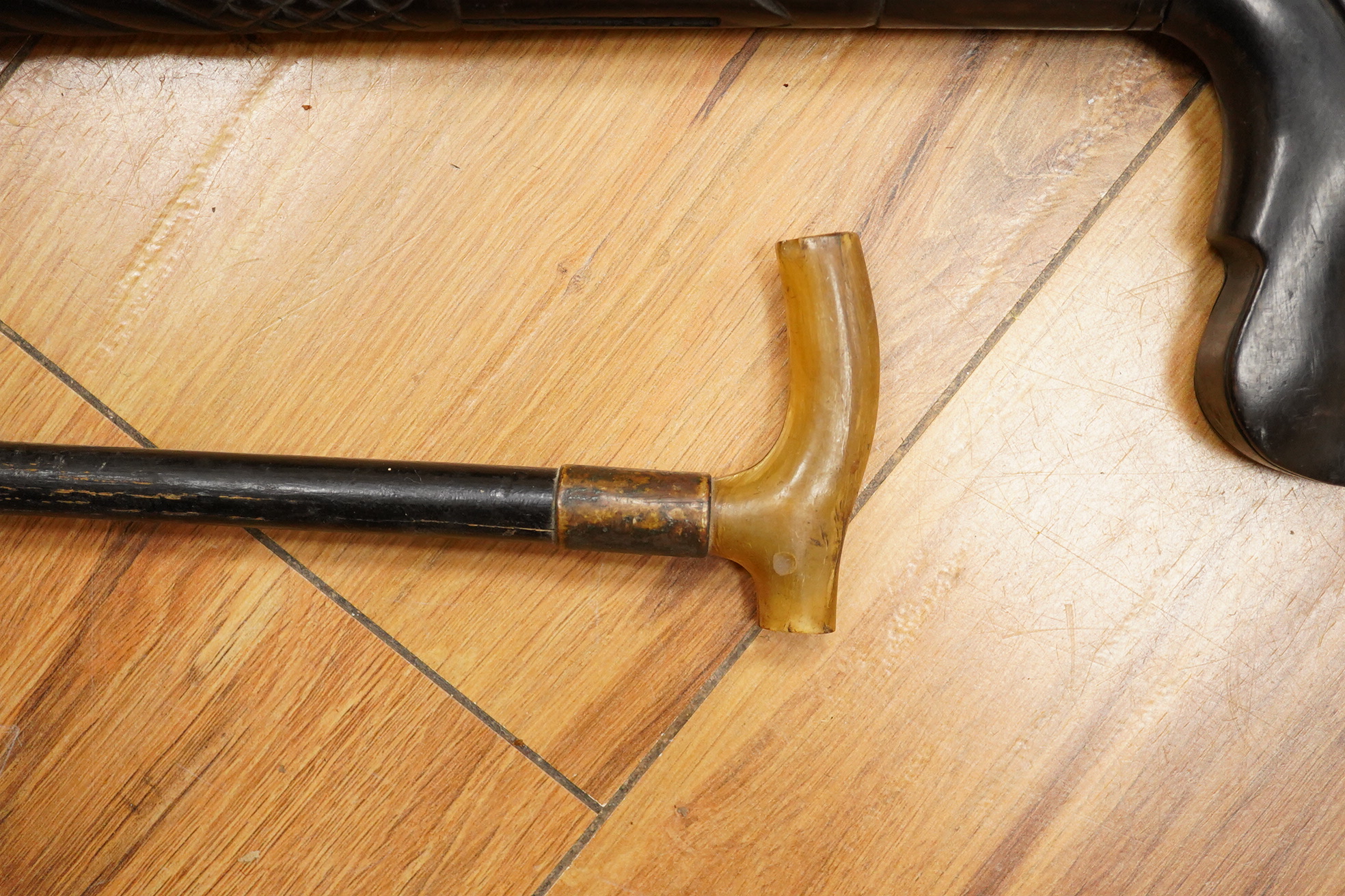 Five walking sticks including horn and a silver topped walking sticks and a carved topped walking stick with concealed chamber containing a metal tube - 93cm long. (5).